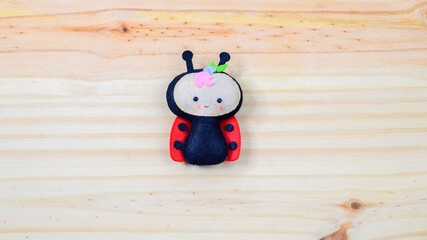Cute handmade ladybug on a wooden background with copy space © nilanka