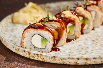 Seared salmon maki with velvety cream cheese and avocado beneath glossy eel sauce for a gourmet food blog © Ryzhkov