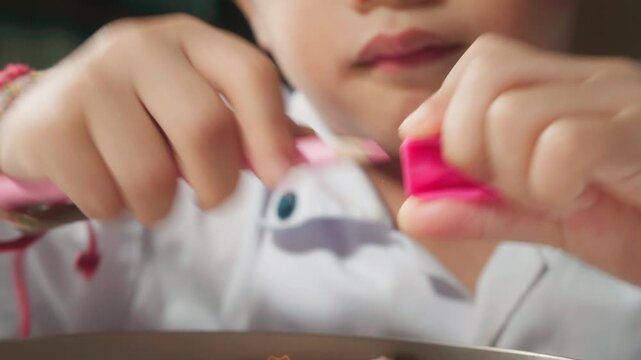Close-up of a young child independently sharpening a colored pencil, practicing hand coordination, finger strength, concentration, and self-care skills.