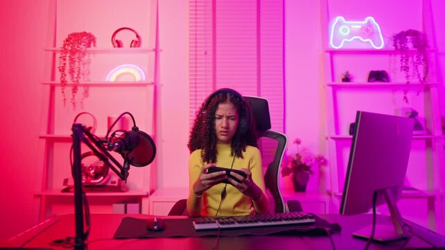 African American teenage girl playing online video game on cellphone. 