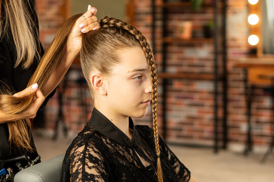 Hairstylist Smoothing High Ponytail For Teen Client In Salon