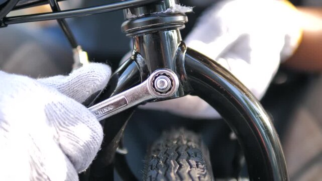 Close-up of a hand using a wrench to tighten a bicycle component during at home maintenance, Fix wrench repair and DIY cycling care