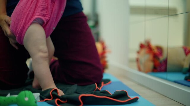 Infant doing prone exercises with a female physical therapist helping with motor skills, balance, and developmental delay