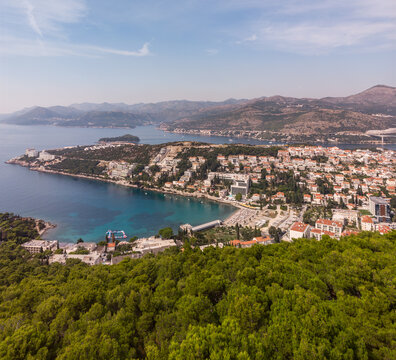 Aerial view of the Adriatic coast in Dubrovnik. Dalmatian cliff coastline with forest and mountains. Bays and beaches in Dubrovnik, drone photo. Summer in Croatia.