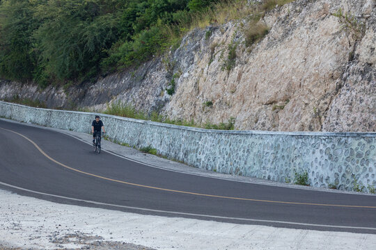 Cyclist Riding on a Scenic Mountain Road