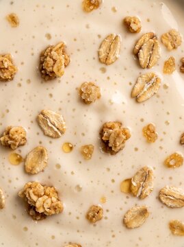 Close-up macro view of creamy yogurt with crunchy granola and oat cereal texture for food packaging design, wellness blog headers, and organic snack marketing campaigns.
