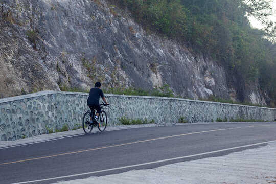 Cyclist Riding Along a Scenic Mountain Road