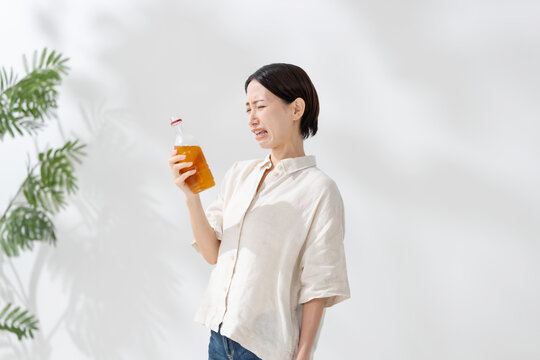 ペットボトルのお茶を飲む女性