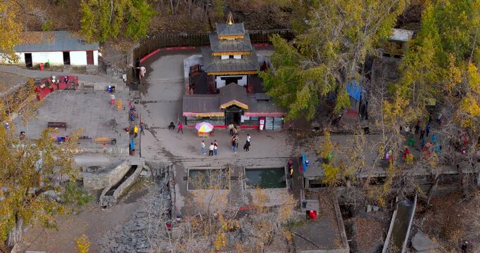 Annapurna Circuit, Mustang, Nepal, aerial shot of the sacred Muktinath Temple complex nestled amidst golden autumn trees in the high-altitude Himalayan landscape.