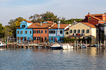 Obraz premium Colorful houses and boats along the Venetian Lagoon on the picturesque island of Burano, Venice, Italy
