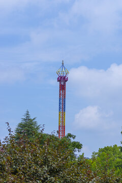Colorful observation tower above trees under blue sky