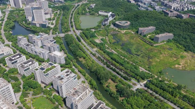Aerial tracking shot over green buildings and an urban park