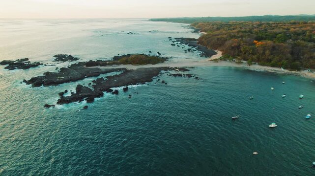 Aerial view of rocky coast and small boats anchored near shore in Costa Rica