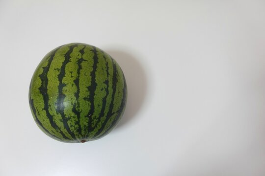 Small whole watermelon photo centered on a clean white surface