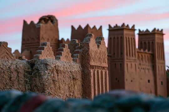Towering earthen walls of a historic Moroccan kasbah with weathered adobe texture and geometric battlements for travel and heritage content