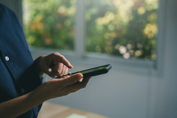Person interacting with a mobile phone screen, connecting to the internet, browsing online content, and communicating digitally