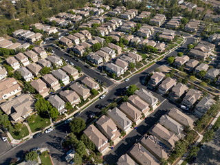 Fototapeta premium Valencia, CA California August 17, 2026: Aerial Drone High View toward Creek Side Community Homes Close-Up with Streets, Threes, Roads, Sunny Day 