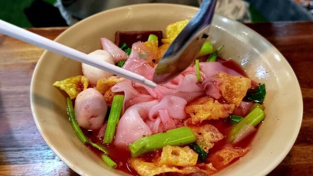 Mixing Wide Rice Noodles with Thai Yentafo Sauce