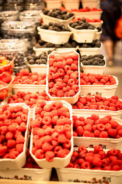 Vertical photo shows raspberries in a display of a local market.