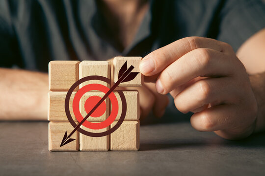 Conceptual image for business: wooden blocks in a drawing target with a dart