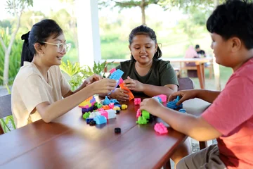 Fotobehang Lego Children's hands play with colorful blocks, building trains and buildings.  © ArvStd