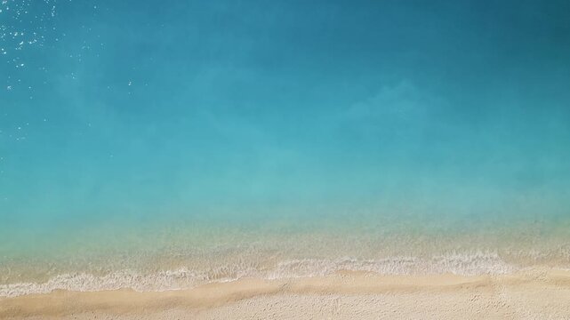 Aerial top down view of calm turquoise water meeting sandy beach in summer Greece