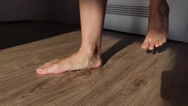 Bare foot with low arch on a wooden floor