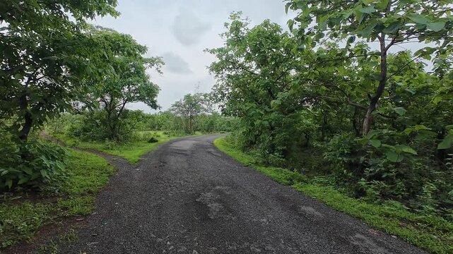 POV Riding  View along Damaged Rural Mountain Road Through Lush Green Sahyadri Forest Under Cloudy Sky