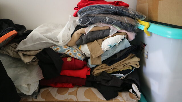 Clothes creating a messy pile in a corner, depicting disorganization, storage issues, and household tasks