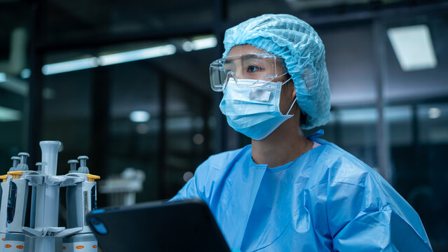 Medical worker in protective gear using lab equipment in a modern research facility