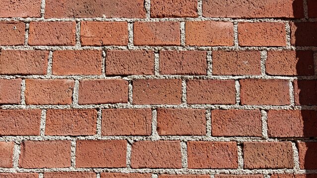 Red brick wall background with detailed masonry texture, rustic architectural surface, vintage building material, grunge urban backdrop.