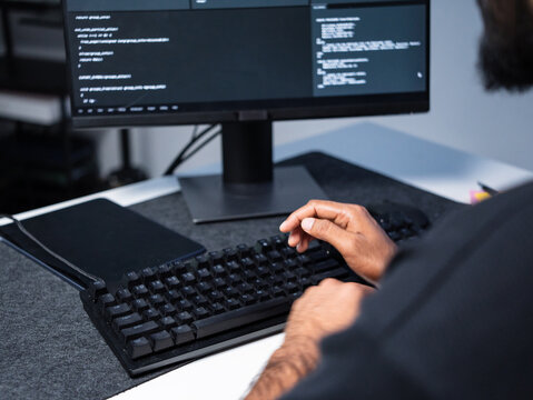 Professional programmer wearing casual clothing typing keyboard computer desktop coding cyber security, software development. Software engineer working use artificial intelligence analysis information