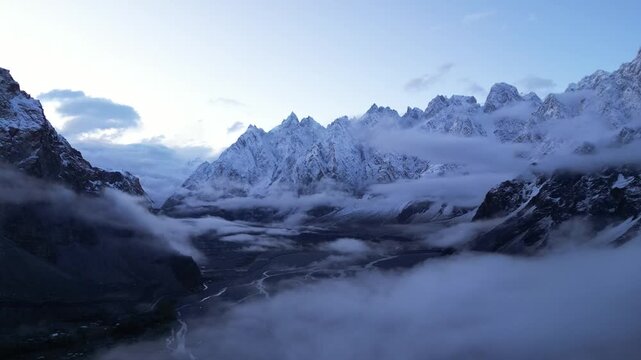 Stunning drone footage of the Passu Cones in Hunza Valley, Pakistan. The dramatic mountainous cathedral peaks dominate the skyline with morning light