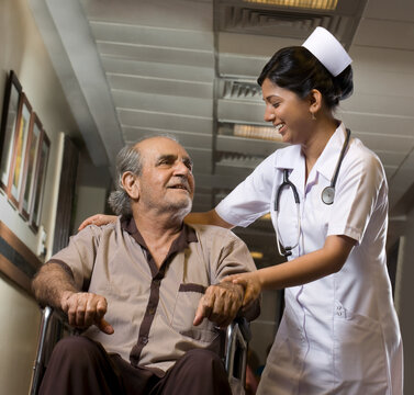 Nurse helping a patient on a wheelchair 