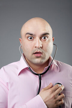 Man using a stethoscope to check his heart rate 