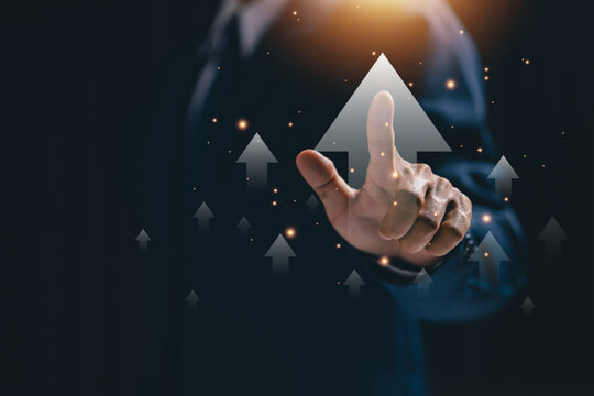 Business professional touching upward arrows on virtual interface, representing business growth, progress, career development, performance improvement, success, and positive strategy.