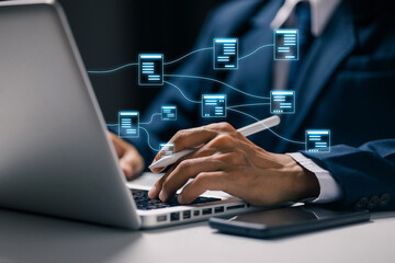 Fototapeta premium Business professional using laptop with connected digital document icons, representing document management, data sharing, cloud workflow, file organization, and business automation.