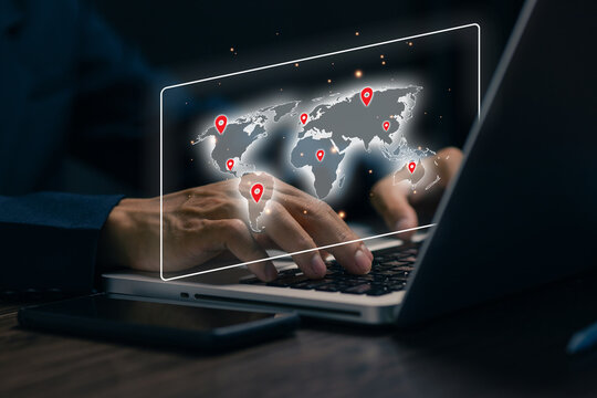 Business professional using laptop with virtual world map and location pins, representing global network, international business, logistics, location tracking, and digital connectivity.