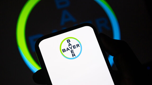 Bayer logo on smartphone screen depicting pharmaceutical and chemical life sciences corporate brand identity.