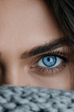 Woman pale blue eye close up eyebrow skin natural beauty female face knitted sweater winter fashion model young adult person human gaze intense