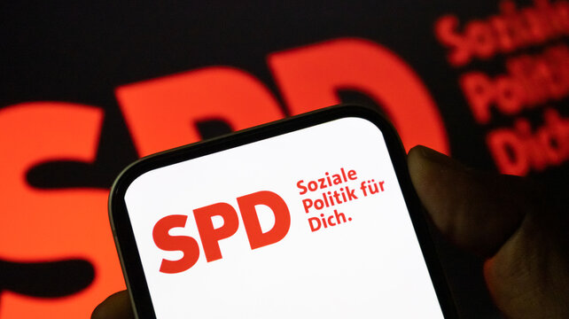SPD political party logo displayed on smartphone screen with social policy slogan background.
