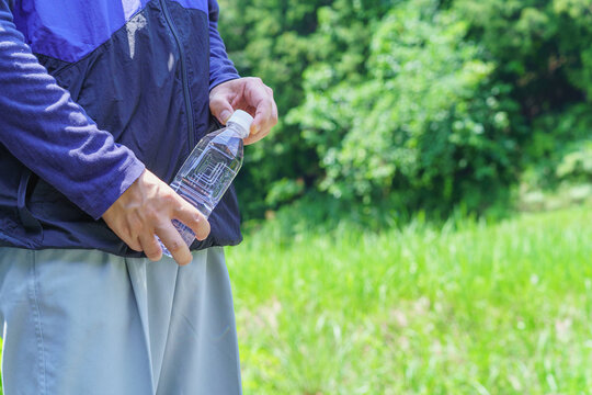 熱中症対策｜炎天下でペットボトルの水を持つ男性