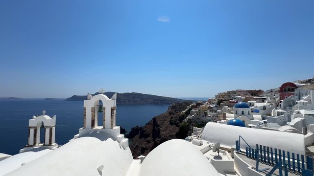 Santorini island, Greece. White cycladic architecture with famous churches in Oia town. Blue sea and the blue sky at sunny day. Panoramic view. Travel and summer vacation concept
