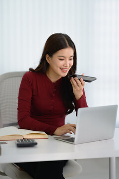 Asian woman using voice assistant AI learning on smartphone