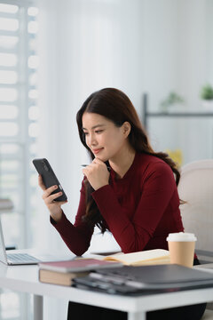 Asian woman using voice assistant AI learning on smartphone