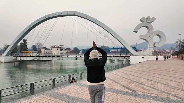 Man walking near Om symbol bridge at Har Ki Pauri ghat in Haridwar Uttarakhand India