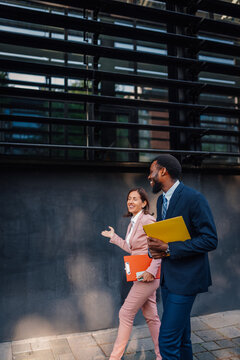 Diverse business professionals walking, communicating in urban setting