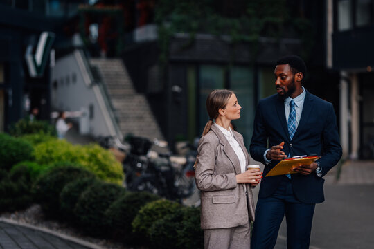 Business colleagues having conversation outdoors discussing work