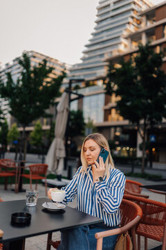 Woman talking on smartphone in urban cafe