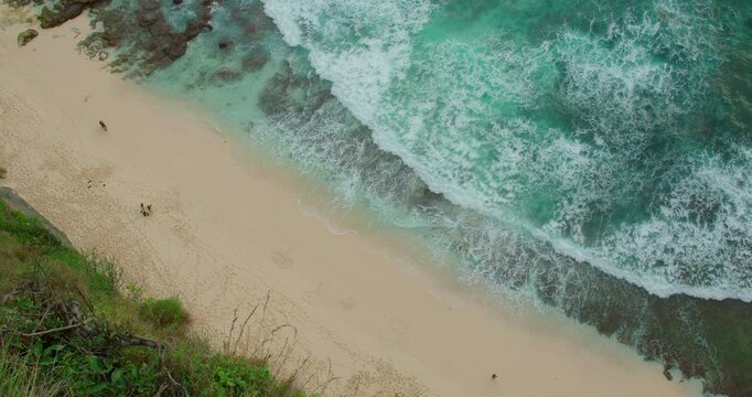 High angle view of waves crashing on white sand beach at Diamond Beach Nusa Penida Island Bali